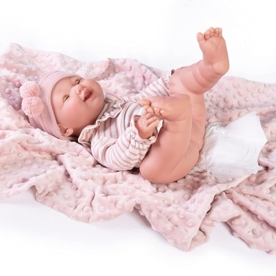 Boneca recém-nascida com roupa e coberta rosa sobre fundo branco