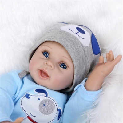 Boneco bebê com gorro cinzento e roupa azul claro com cão desenhado
