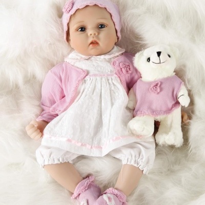 Boneca bebé com ursinho em fundo branco felpudo