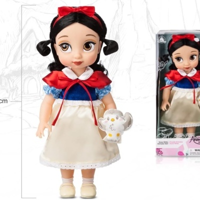 Boneca Branca de Neve de 39 cm em caixa transparente, vestindo roupa colorida e segurando bule branco.