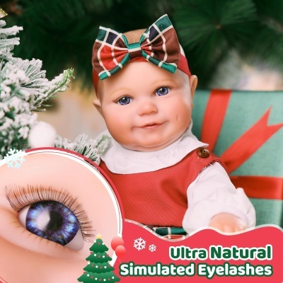 Boneca bebé com laço xadrez e cílios postiços azuis em cenário de Natal