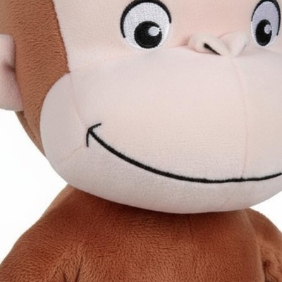 Pelúcia de macaco castanho e creme com rosto sorridente e olhos bordados