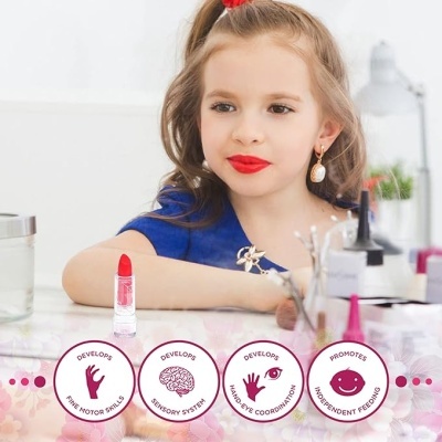 Menina com batom vermelho sentada à mesa com produtos de beleza e batom vermelho aberto.