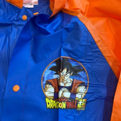 Capa de chuva azul e laranja com estampa de Goku e texto DRAGON BALL SUPER
