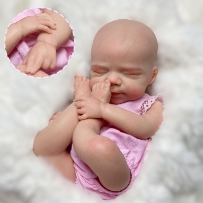Boneca realista de bebé em tecido rosa sobre fundo branco macio