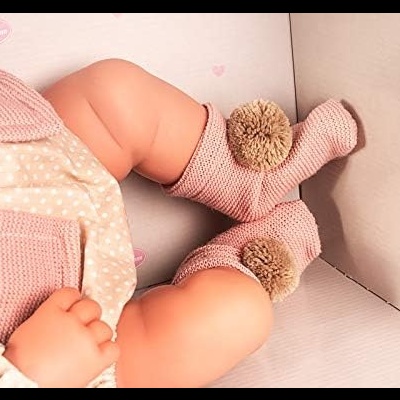 Pernas de bebé com meias cor-de-rosa e pompons