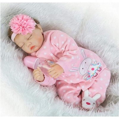 Boneca bebé a dormir com pijama rosa e faixa de cabelo com flor
