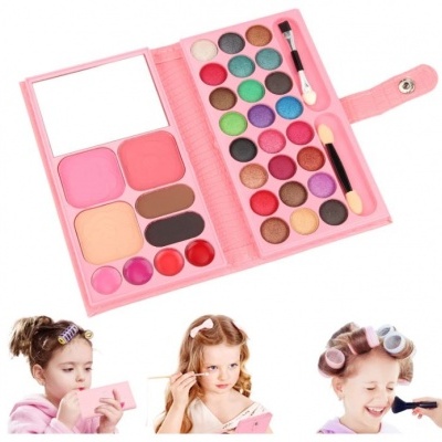 Paleta de maquilhagem rosa com várias sombras, blushes e lábios, com espelho e pincéis.