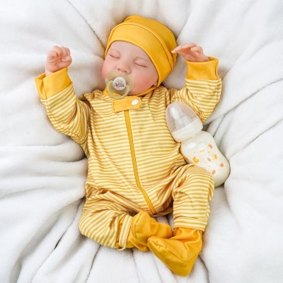 Bebé a dormir com fato pijama amarelo às riscas com chupeta e biberão