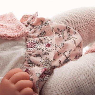 Bebé ou boneca com roupa rosa floral, meias rosas e casaco de malha rosa