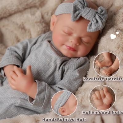 Boneca realista de pijama cinzento com faixa de cabelo laço, deitada sobre manta felpuda creme