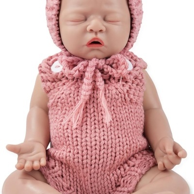 Boneca bebé com roupa rosa de malha sentada