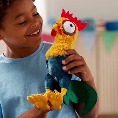 Brinquedo de peluche em forma de galinha colorida nas mãos de uma criança