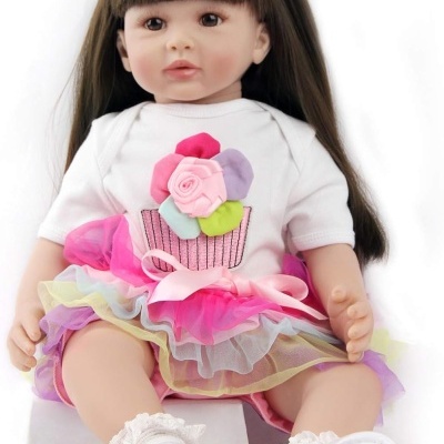 Boneca de bebé com vestido branco e saia de tule colorida sentada