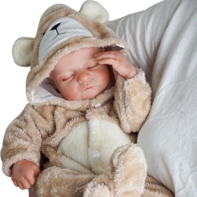 Boneco bebé com fato pele de urso bege e branco deitado