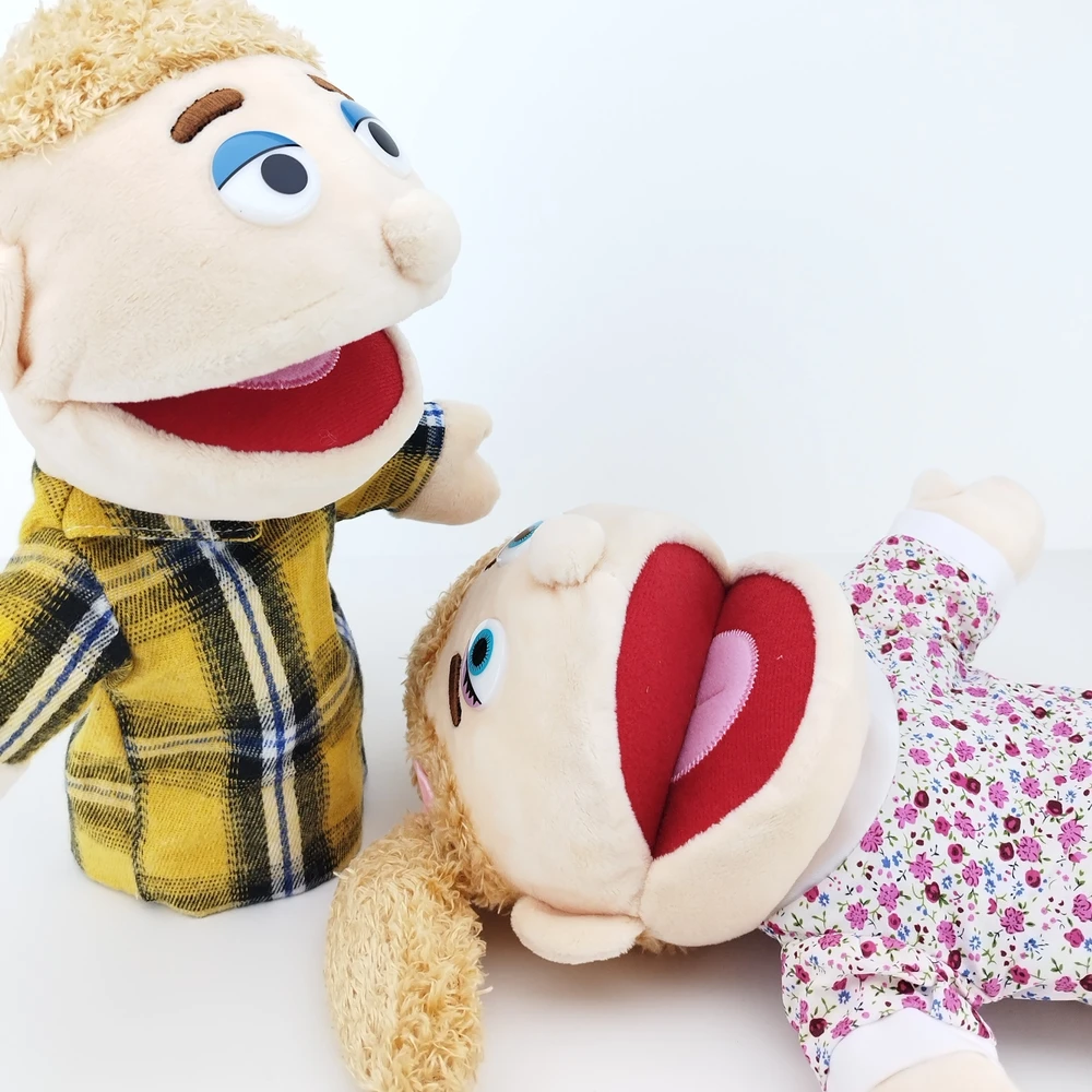 Fantoche de Mão em Tecido 30 cm Duas marionetas de mão vestidas, uma com camisa xadrez amarela e outra com vestido floral.