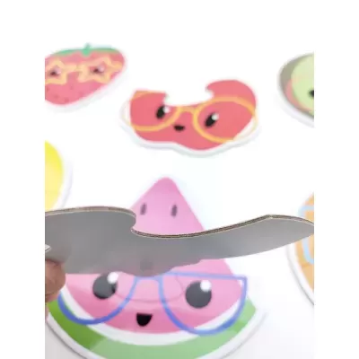 Peça de puzzle de cartão com imagem de fruta cor-de-rosa com óculos azuis.