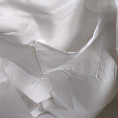 Peça de vestuário branca com etiqueta de cuidados costurada