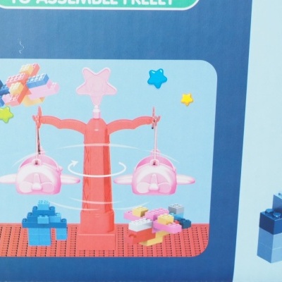 Caixa de brinquedo de construção com torre cor de rosa e blocos coloridos