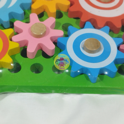 Peças de engrenagem de madeira coloridas montadas numa base verde