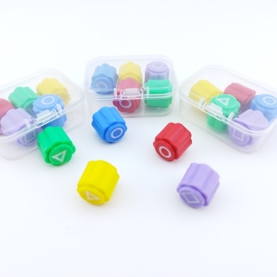 Peças plásticas coloridas com símbolos geométricos em caixas transparentes