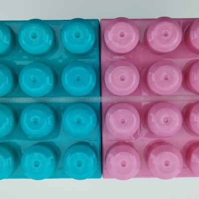 Tampas de garrafas de plástico azul e rosa organizadas em placas retangulares