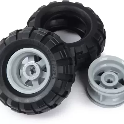 Conjunto de três rodas de brinquedo, duas com pneus pretos e uma cinzenta clara, sobre fundo branco.