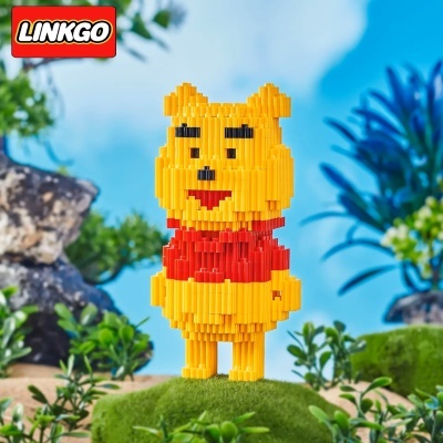 Figura de blocos amarelo e vermelho semelhante ao Ursinho Pooh em ambiente natural