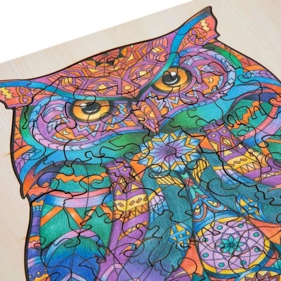 Puzzle de coruja colorida em madeira com padrões geométricos