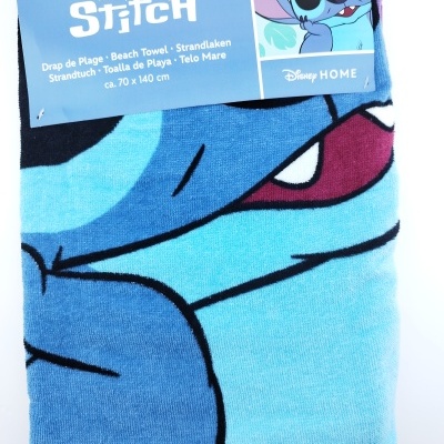 Toalha azul com desenho do personagem Stitch da Disney e etiqueta azul com informações do produto
