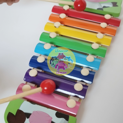 Xilofone colorido de madeira com vacas e baquetas vermelhas