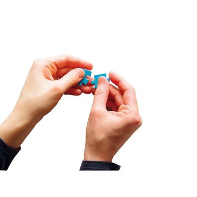 Mãos seguram peças azuis de um quebra-cabeças sobre fundo branco