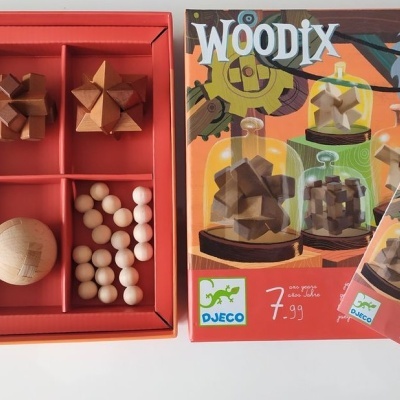Conjunto de brinquedos de madeira WOODIX da marca DJECO em caixa vermelha com várias peças geométricas.