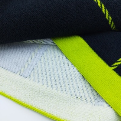 Toalha colorida com padrões em verde neon, branco e azul escuro