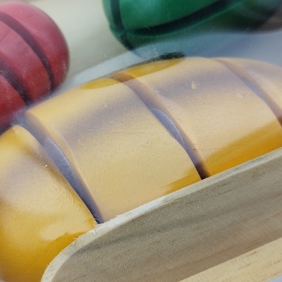 Alimentos de brinquedo em madeira colorida dentro de uma caixa de madeira