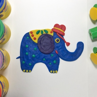 Elefante azul de massa moldável com recipientes de massa e ferramentas verdes e amarelas