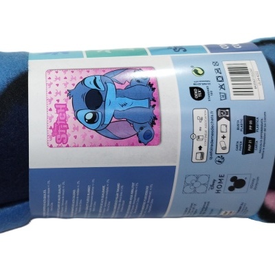 Manta polar azul, rosa e preta com etiqueta mostrando Stitch e instruções de lavagem