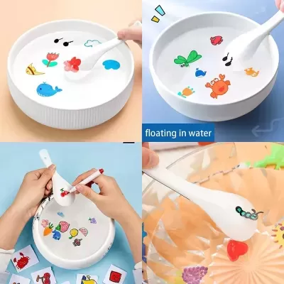 Tigela branca com autocolantes coloridos de animais e planta, mexendo água com colher branca