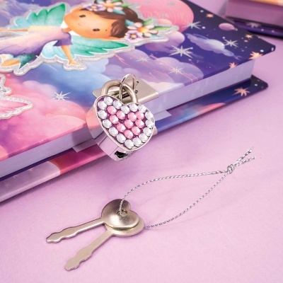 Caderno decorado com fada e cadeado em forma de coração com pedras rosa, chaves prateadas sobre fundo cor-de-rosa
