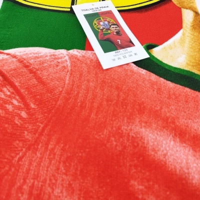 Toalha de praia com cores da bandeira de Portugal e etiqueta com texto em português