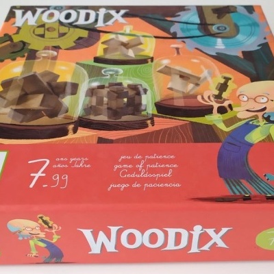 Embalagem colorida do jogo WOODIX com peças de madeira e personagem desenhado.