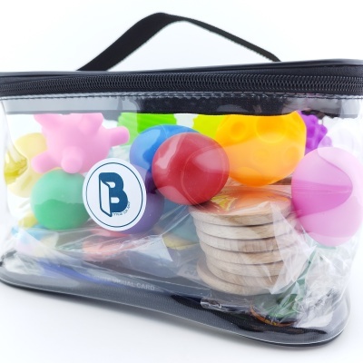 Bolsa transparente com brinquedos coloridos de plástico e madeira