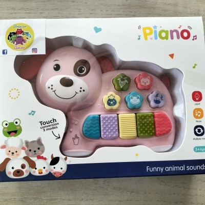 Brinquedo piano infantil em forma de cão cor-de-rosa com botões coloridos em caixa branca