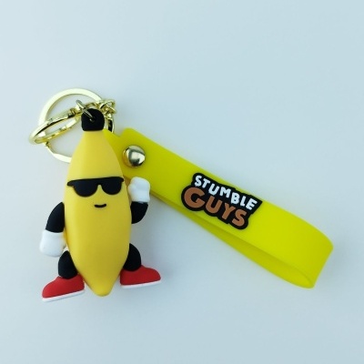 Chaveiro de banana estilizada com fita amarela e texto STUMBLE GUYS