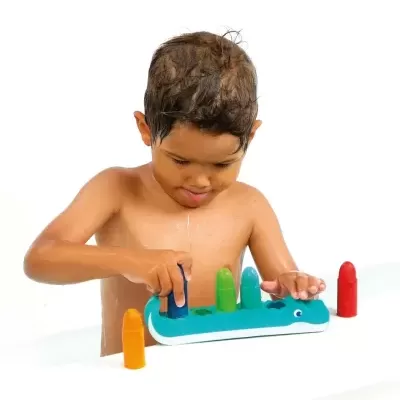 Criança a jogar com brinquedo de encaixe colorido em forma de crocodilo azul.