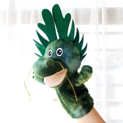 Fantoche de mão verde com crista e olhos grandes contra cortinas brancas