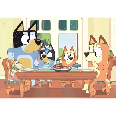 Família de cães animados à mesa com pratos e frigideira com comida, brinquedo de macaco na cadeira.