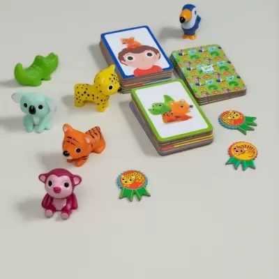 Jogo de cartas infantis com figuras de animais coloridos em plástico e cartas sobre fundo cinza claro.