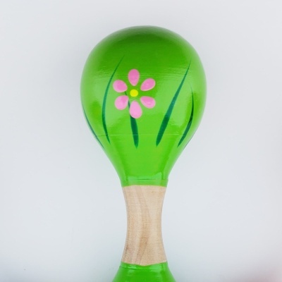 Maraca de madeira verde com flor pintada e cabo natural