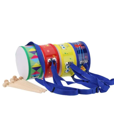 Três tambores de brinquedo coloridos com baquetas de madeira